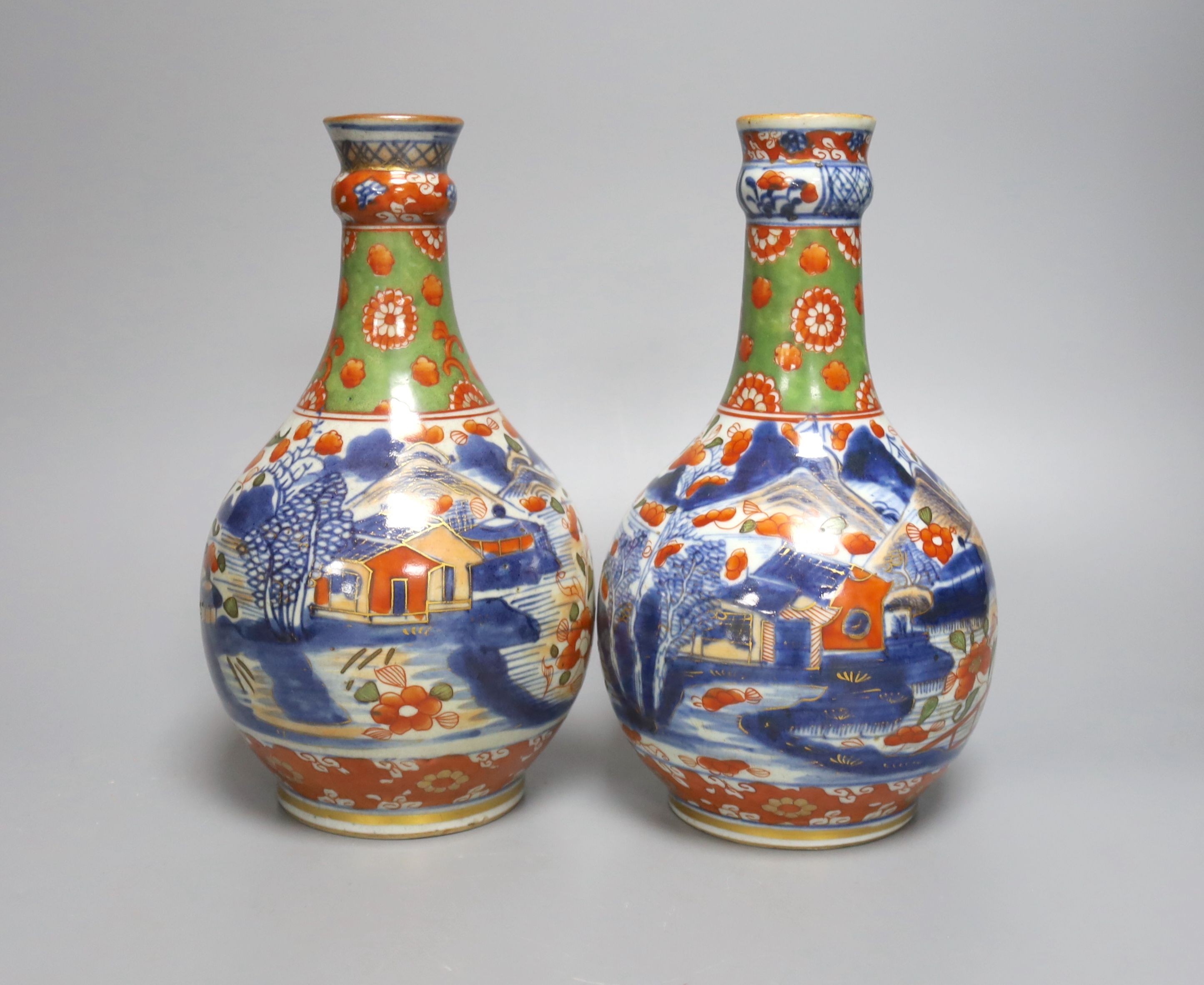 A pair of 18th century Chinese clobbered blue and white bottle vases 23cm